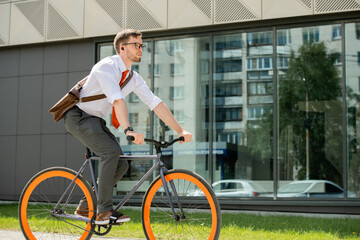 Young businessman sitting on bicycle and moving to appointment with client