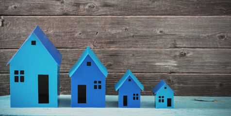 Obraz na płótnie Canvas blue paper houses stands over wooden background