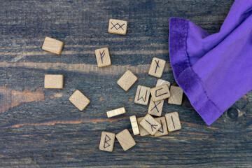 Scandinavian wooden runes on an old wooden table. Elder Futhark.