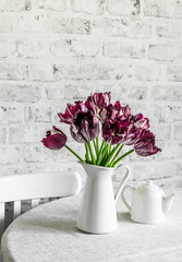 Bouquet of  tulips on a table in a light kitchen room. Cozy home concept, copy space