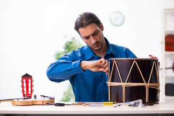 Young male repairman repairing drum