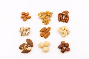 Variety of nuts isolated on white background. Heaps of nuts, peanuts, hazelnuts, almonds,brazil nuts, walnuts, pistachios, Macadamia, pecan and cashew 