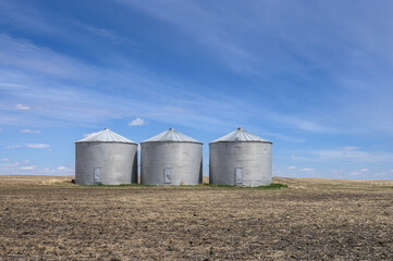 Round metal grain storage bins near the city of Airdrie, Alberta, Canada