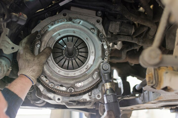 Car repair in a car service. Replacing the clutch disc of a gearbox on a car at a service station....