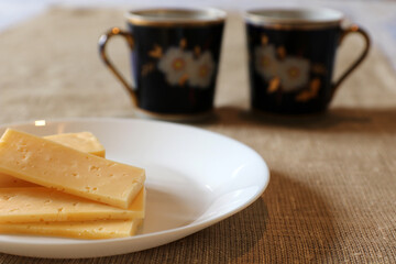 Obraz na płótnie Canvas Slices of cheese on a plate. Selective focus.