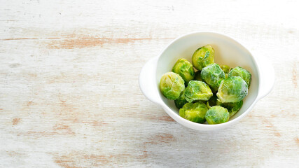Frozen fresh green brussels sprouts. Food supplies. Top view. Free space for your text.