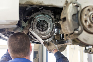 Car repair in a car service. Replacing the clutch disc of a gearbox on a car at a service station....