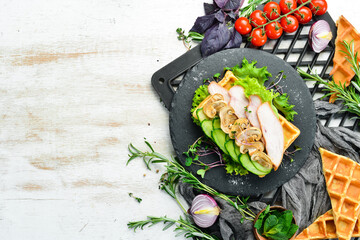 Belgian waffles with chicken fillet, mushrooms and cucumber. Belgian food. Top view. Free space for your text.