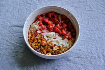 Healthy Vegan Homemade Breakfast. Oatmeal with strawberry sauce, coconut and granola.