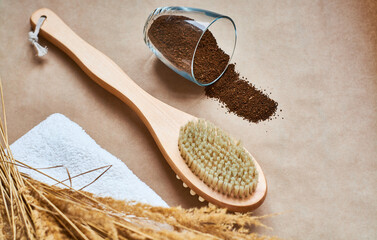 Brush, washcloth for body massage and skin cleaning with natural coffee scrub on beige background. Spa.