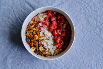 Healthy Vegan Homemade Breakfast. Oatmeal with strawberry sauce, coconut and granola.