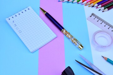 concept office supplies, scissors with red handles, stapler with paper clips, pen, ruler and other...