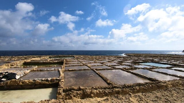 Time lapse - Salt pans for harvest on the Mediterranean sea coastline on a beautiful sunny day in Gozo, Malta, Europe