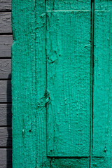The natural surface, of painted vertical boards. The surface of the old wooden facing wall of the house. Cracked paint covers the texture of wooden boards.