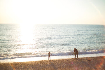 family walks on the seashore at sunset