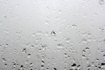 Few raindrops on the window pane close up outside the window gray sky