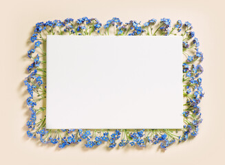 a frame of small blue flowers woven in the shape of a rectangle