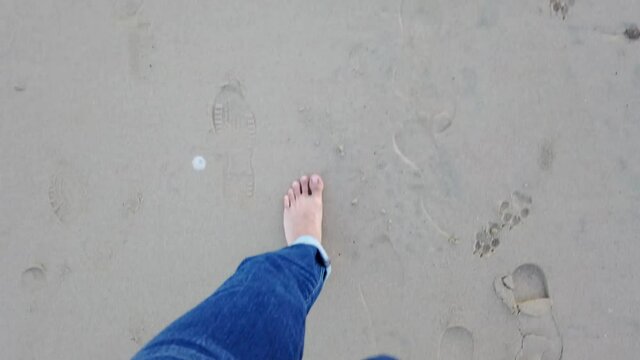 pies caminando por la arena en la playa