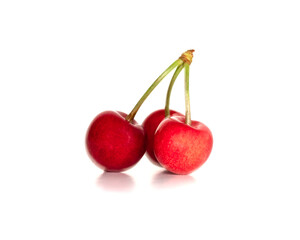 Three red juicy sweet cherries with pits on a white isolated background close-up