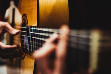 Fototapeta premium The hands of a young man playing acoustic guitar. Spanish guitar.