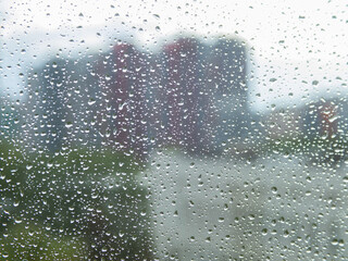 Naklejka na ściany i meble the city blurred through the windshield with drops of rain