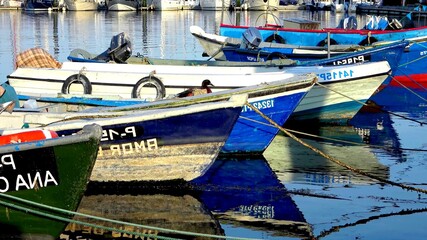 Fototapeta na wymiar Small fishing boats on a quiet water of an harbor