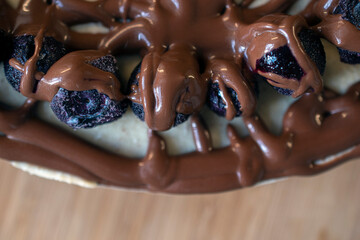 Delicious and decadent layered cheesecake dessert topped with fresh blueberries and drizzled with melted chocolate topping