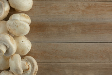 champignon mushrooms on a wooden background. Fresh mushrooms on wooden background