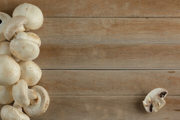 champignon mushrooms on a wooden background. Fresh mushrooms on wooden background