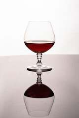 Glass with brandy on a reflective background
