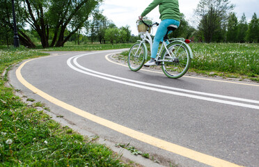 Naklejka premium Woman riding a bike on bike path with markings in park