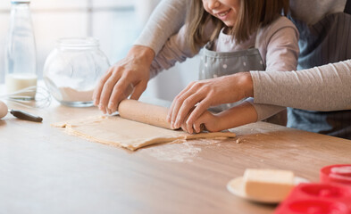 Father Showing His Cute Little Daughter How To Roll Dough For Cookies