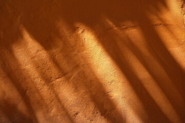 Leaves Shadow on Orange Paint Concrete Wall Texture Background.