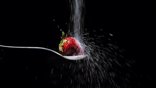 Fresa roja con hojas verdes impacta az&uacute;car en slow motion c&aacute;mara lenta