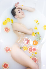 Obraz premium An attractive girl takes a bath with milk and flowers. Spa treatments for skin rejuvenation