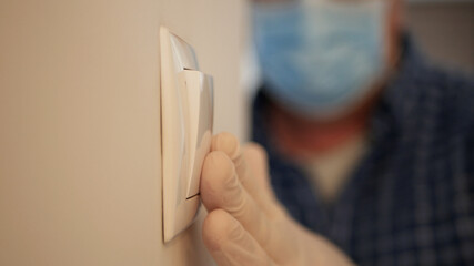 Man Wearing Medical Mask and Protection Gloves Enter in the Office Room Turning On the Light from the Switch on the Wall