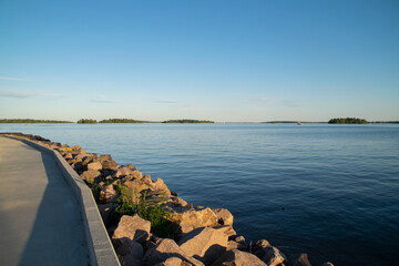 View from the pier of the calm water on the lake. Photo taken on a beautiful summer evening in Sweden.