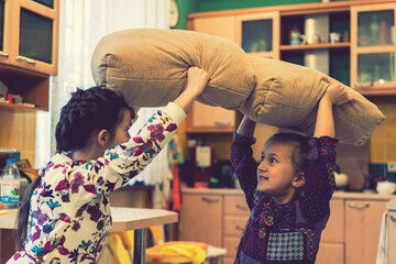 happy teen girl friends fighting pillows at home. toned