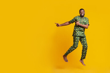 Excited black guy jumping and pointing at free space