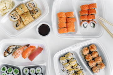 Set of rolls and sushi in a plastic box top view. Delivery service consept.