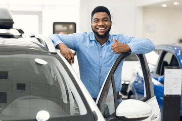 African Man Gesturing Thumbs-Up Approving Automobile After Test-Drive In Dealership