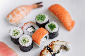Mix of sushi and rolls close up on white background.