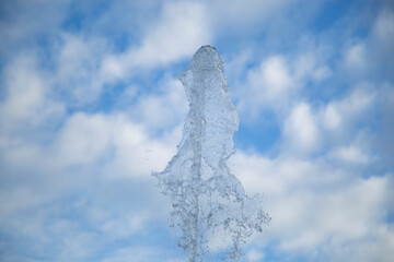 Clean and artesian water from the well. A stream of water against the sky.