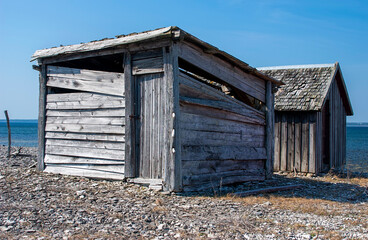 Old wooden cottages on cobblestone beach, Sweden