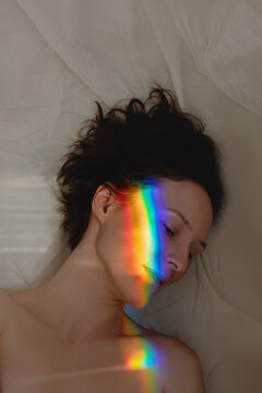 Woman with a spectrum light on her face.