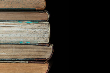 stack of old books on a black background. Pile of retro books