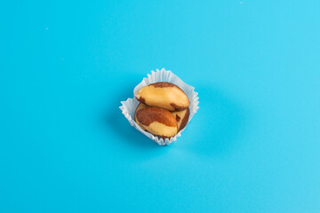 serving of brazil nuts in a paper muffin cup on a blue background