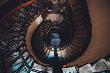Destroyed spiral staircase indoors. Natural light. Beautiful architecture. Old apartment building in Saint Petersburg. Winding stair. Devastated ruins