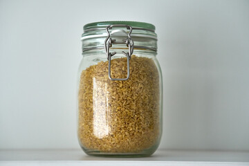  Glass jars with a lid for food on a white shelf. Storage in the kitchen. Containers with bulk products. Transparent container.