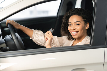 Woman Showing Car Key Sitting In Driver's Seat In Vehicle